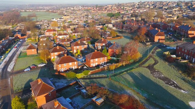 Drone's-eye winter view captures Dewsbury Moore Council estate's typical UK urban council-owned housing development with red-brick terraced homes and the industrial Yorkshire. Working class housing