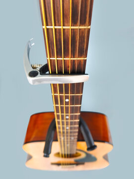 capo on guitar fingerboard selective focus.