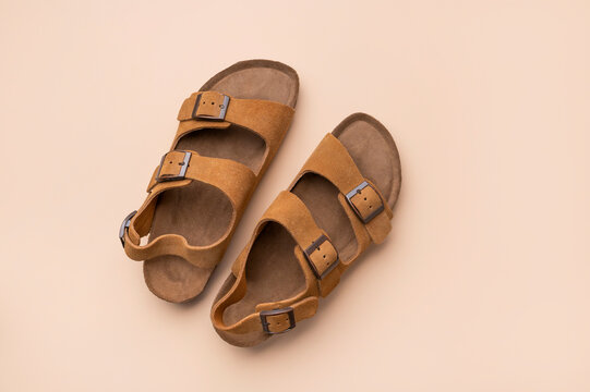 Stylish summer sandals. Women's or men's open-toe shoes, top view copy space. Fashion, comfortable footwear, wardrobe essential. Brown leather sandals with cork soles.