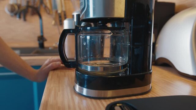 Woman prepares morning coffee on the kitchen