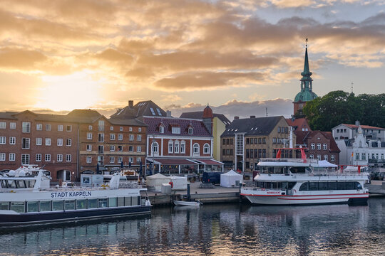 Kappeln harbor quay at sunset ships docked in Schleswig-Holstein Germany with historic buildings and church spire golden hour travel destination