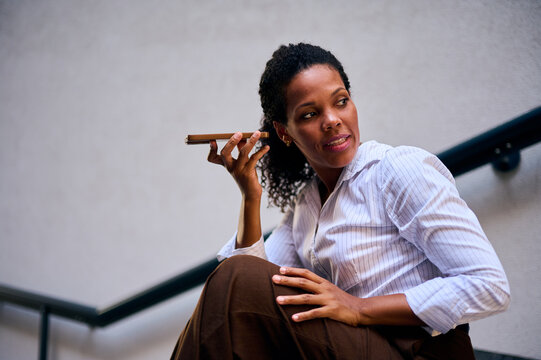 African American Businesswoman Using Phone Speaker Outside Office Stairs Showing Confidence And Professionalism
