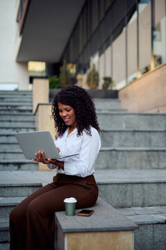 African American Woman Using Laptop On Urban Steps For Remote Work And Professional Branding