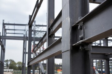 Fototapeta premium Steel frame structure under construction, highlighting industrial simplicity with a blurred background.