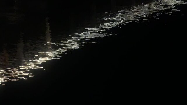 Moonlight reflection glimmering on dark water surface