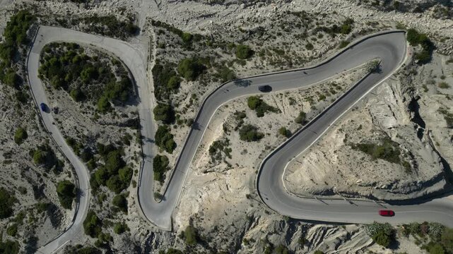 Aerial view of cars driving on winding mountain pass road
