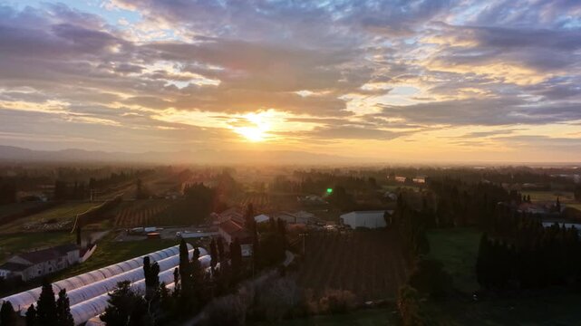 Drone pulling away from sunrise over Provence countryside, France
