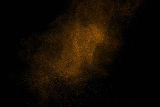 Abstract brown dust particles floating in the air on black background, creating a dynamic powder cloud with fine particle dispersion, motion effect, cinematic texture, and high speed freeze action.