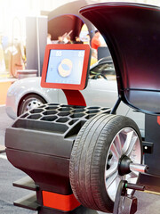 Modern Wheel Balancer Machine with Car Tire at Auto Service © Sergey Ryzhov