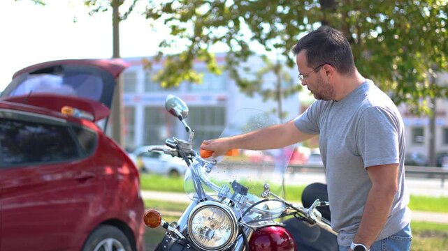 Watch as this dedicated middle-aged man lovingly wipes down his motorcycle after a thorough wash. His attention to detail ensures that every inch shines, showcasing his passion for biking.