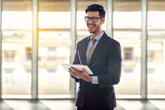 A corporate employee in formal business suit holding a digital tablet addressing a conference.