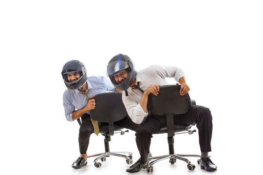 Corporate employees in formal clothing enjoying by wearing helmets and playing.