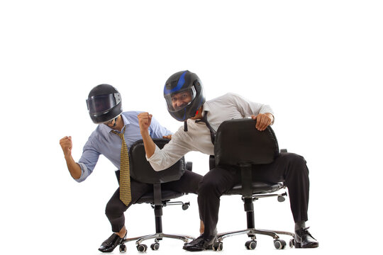 Corporate employees in formal clothing enjoying by wearing helmets,playing and celebrating by closing fist.