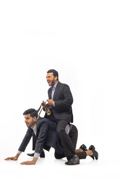 A boss riding on subordinate's back while holding his necktie like a dog collar.