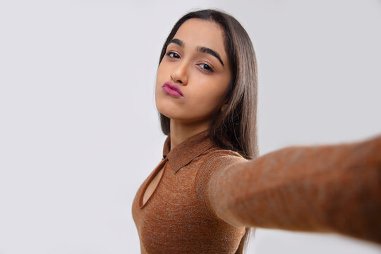Young girl showing duck face while taking selfie