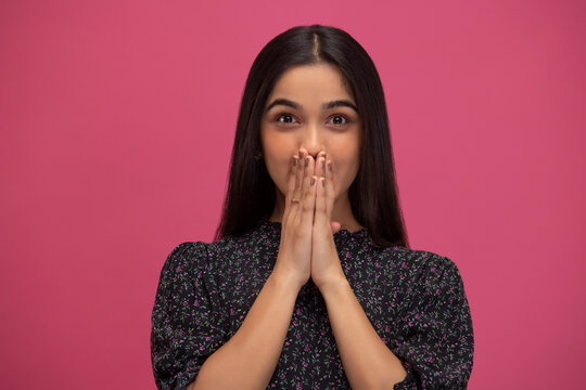 Portrait of a young surprised girl with covering mouth with hands