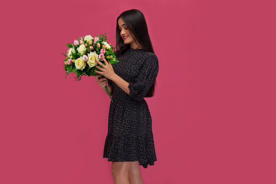 Beautiful girl posing with holding a flower bouquet