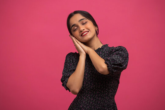 Portrait of young smiling girl showing sleeping pose