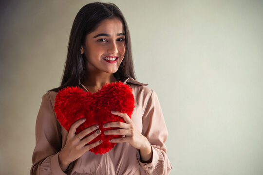Portrait of a young girl with heart shaped cushion