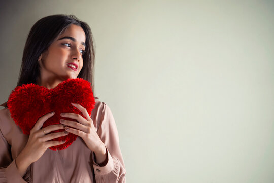 Portrait of a young girl with heart shaped cushion