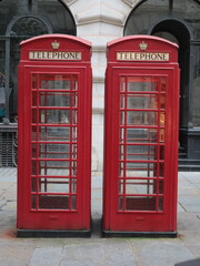 Fototapeta premium Iconic Red British Telephone Boxes in London, England, Traditional Public Phone Booths, Historic UK Landmark, Classic Urban Street Architecture, Travel and Tourism Destination