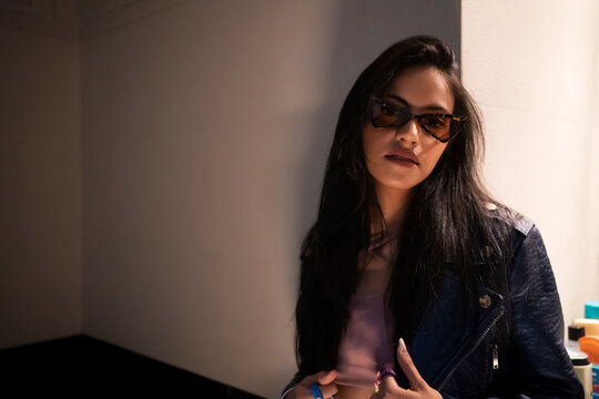 A young,Stylish woman wearing a crop top and leather jacket .