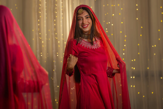 Young adult woman in traditional clothing posing in front of mirror 