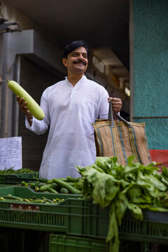 Middle age man shopping bottle gourd in market