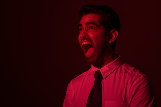 Portrait of an angry young man looking away and shouting
