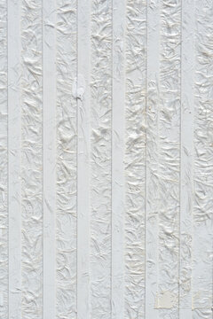 A full frame shot displays a textured white fiberglass panel surface featuring alternating smooth and fibrous vertical striped sections