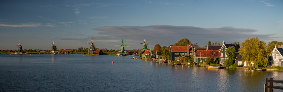 Panoramic view of historic windmills and traditional Dutch village on the waterfront at Zaanse Schans.
