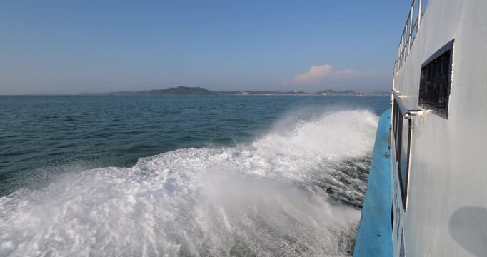 Forward view from old passenger ferry sailing at full speed from Tioman Island to Mersing. White side wake with splashes rising at bow