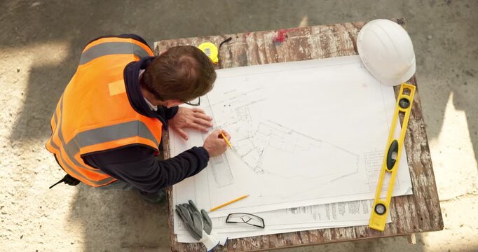 Man, engineer and writing at site with blueprint, document and measure design for architecture. Above, male person and drawing on paperwork with ruler, floor plan and illustration for building layout