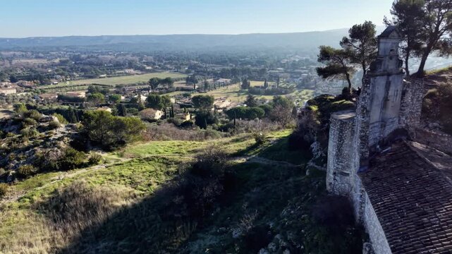 Drone flying past historic stone ruins overlooking countryside in Provence, France