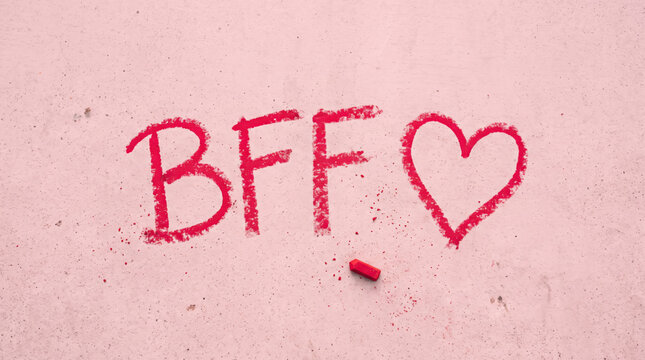 Handwritten BFF text with heart on soft pink background, celebrating friendship, best friends forever, love, loyalty, meaningful connections, affection, companionship and lasting relationships.