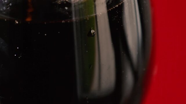 Refreshing dark beverage served in elegant glass with condensation on a vibrant background