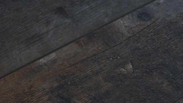 Moving a gift box on a wooden table and changing its position slightly