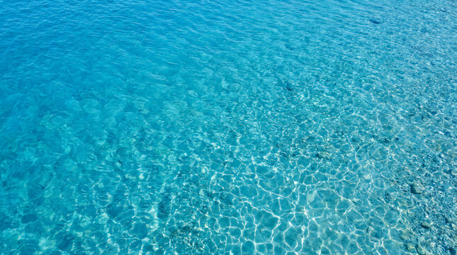 Clear turquoise water with visible ripples and light reflections on the surface, creating a calming and refreshing scene.