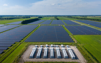 Aerial view of a large-scale solar farm featuring extensive rows of photovoltaic panels and a battery energy storage system in the rural landscape of Wanneperveen, Overijssel, Netherlands. © Ewout Pahud