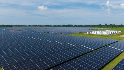Aerial view of a large-scale solar farm featuring extensive rows of photovoltaic panels and a battery energy storage system in the rural landscape of Wanneperveen, Overijssel, Netherlands. © Ewout Pahud