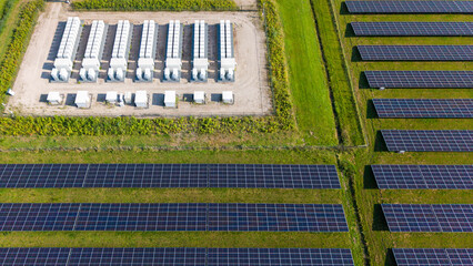 Aerial view of a large-scale solar farm featuring extensive rows of photovoltaic panels and a battery energy storage system in the rural landscape of Wanneperveen, Overijssel, Netherlands. © Ewout Pahud