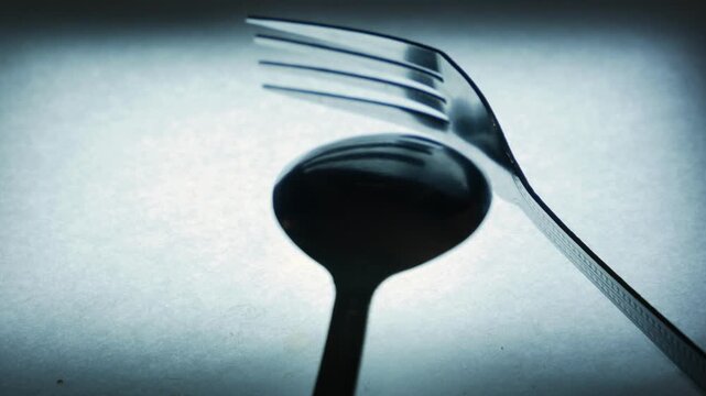 Metal Spoon and Fork on Textured Surface
