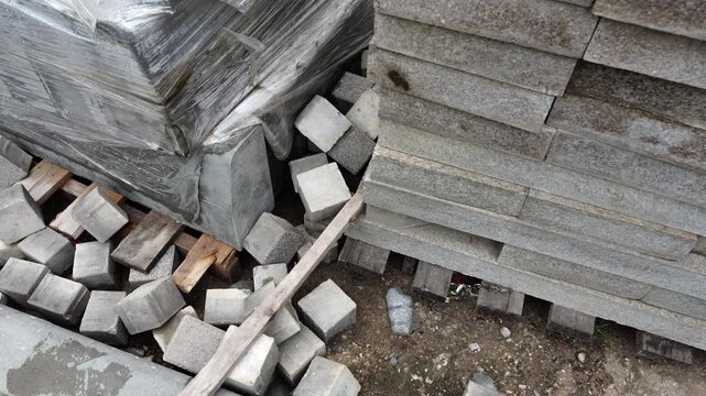 Stacked concrete slabs and construction materials stored outdoors, industrial building supplies and infrastructure elements for construction projects