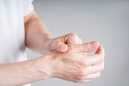 Close up of man massaging painful thumb. Smartphone thumb, trigger finger or carpal tunnel syndrome medical concept