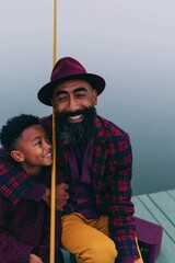 Fototapeta premium Father and son fishing on a foggy dock lifestyle portrait with warm autumn colors for family background and banner design