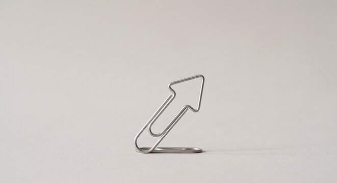 Silver paperclip bent into a rising arrow business growth concept