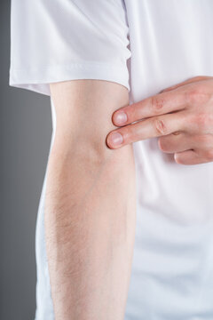 Close up of man holding painful arm with inflamed vein, concept of phlebitis or thrombosis