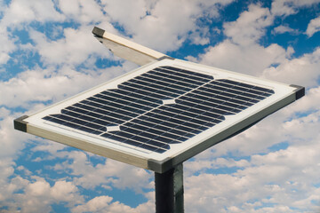 Obraz premium Solar panels against white clouds in the blue sky - close up view. Renewable energy, ecological, alternative source of electricity, and technology concept