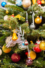 Obraz premium A Christmas tree stands with many colorful ornaments hanging from its branches. Each ornament shows different shapes and colors, celebrating the festive season and bringing joy to the home
