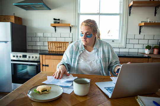 Woman managing bills and budget at kitchen table